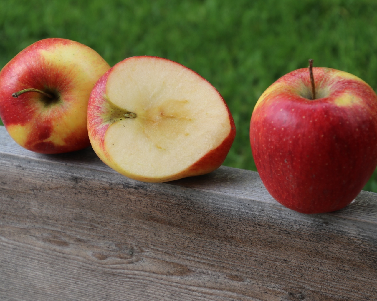 Красные яблоки лежат на деревянной доске