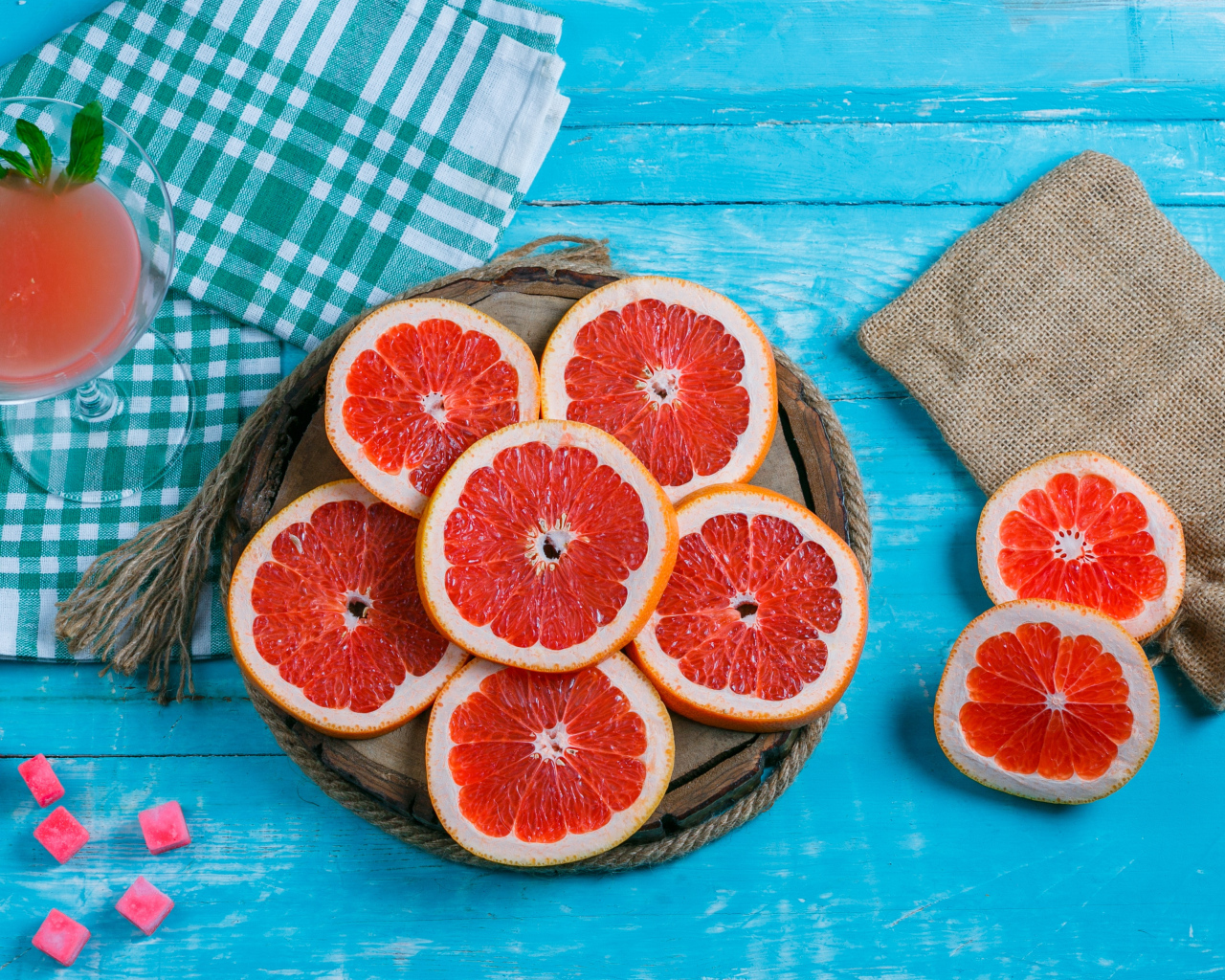 Нарезанный грейпфрут с соком на голубом столе