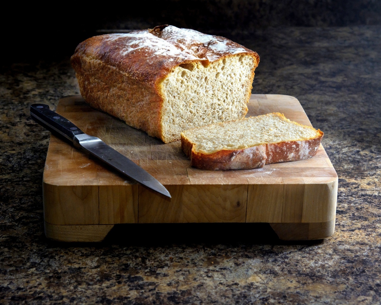 Буханка хлеба с ножом на столе
