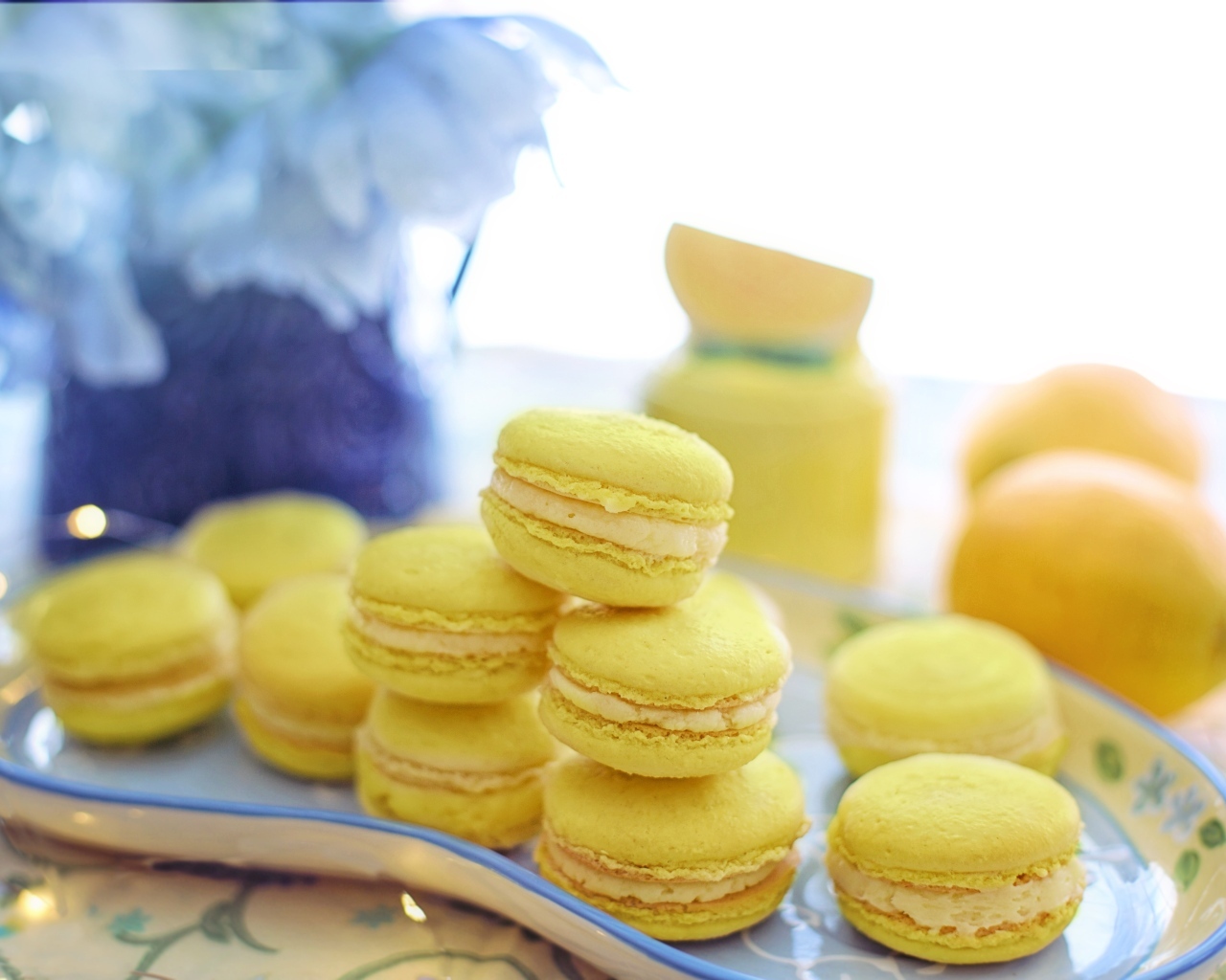 Десерт макарунс желтого цвета на тарелке на столе