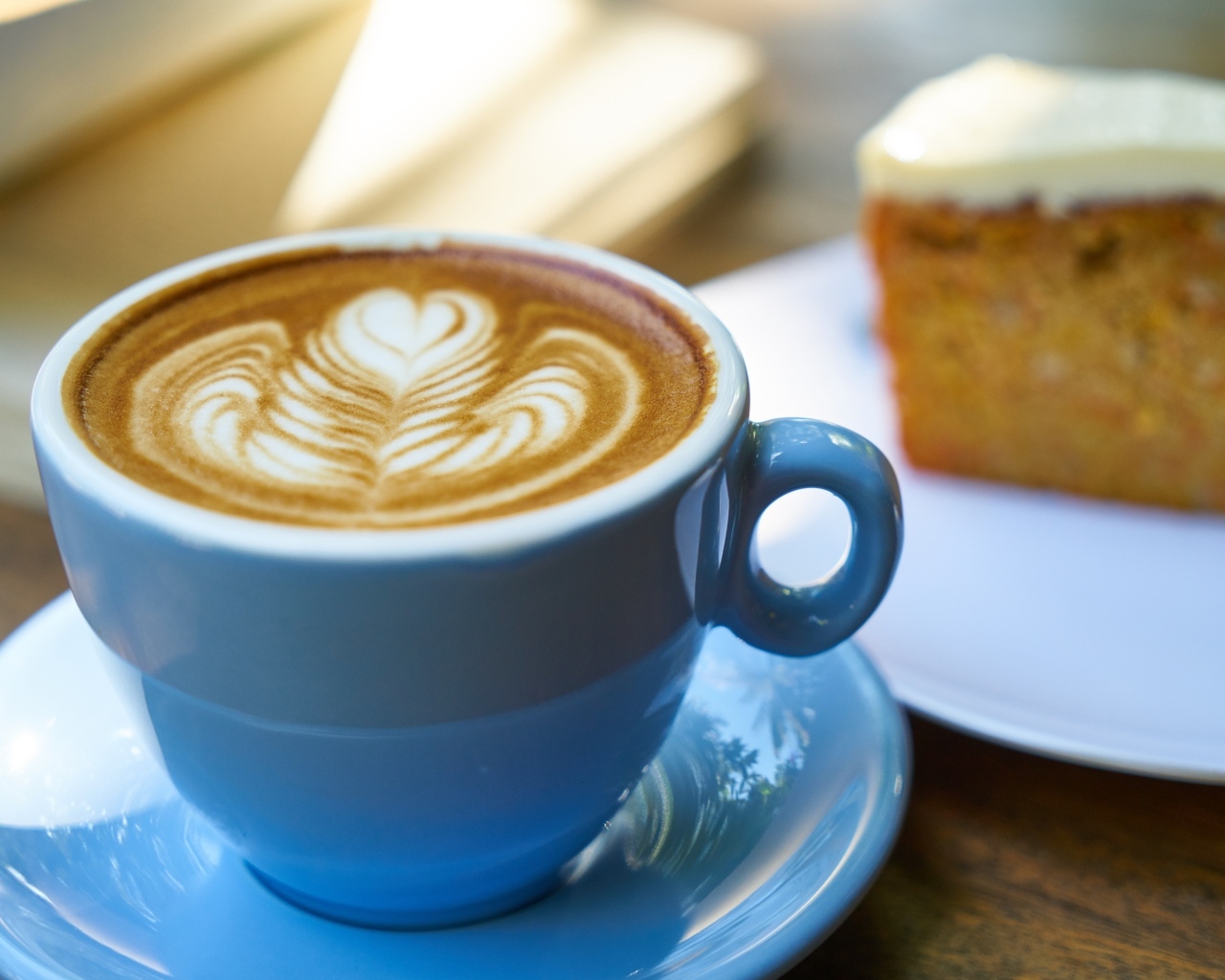 Чашка ароматного горячего кофе с рисунком на пене на столе на завтрак