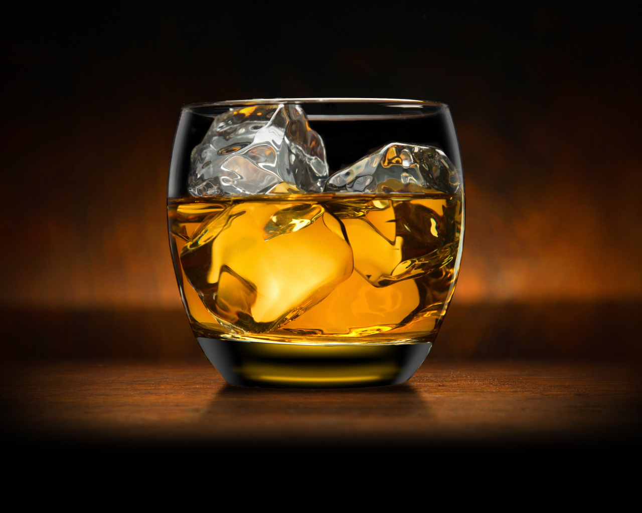 Стакан виски со льдом на столе