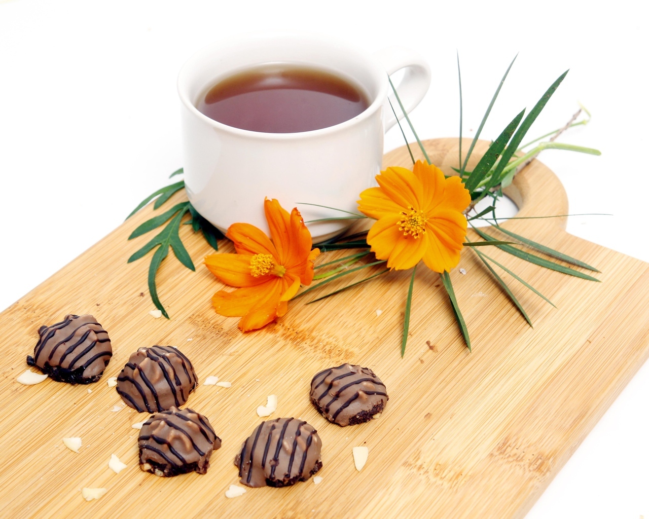 Чашка чая на деревянной доске с конфетами