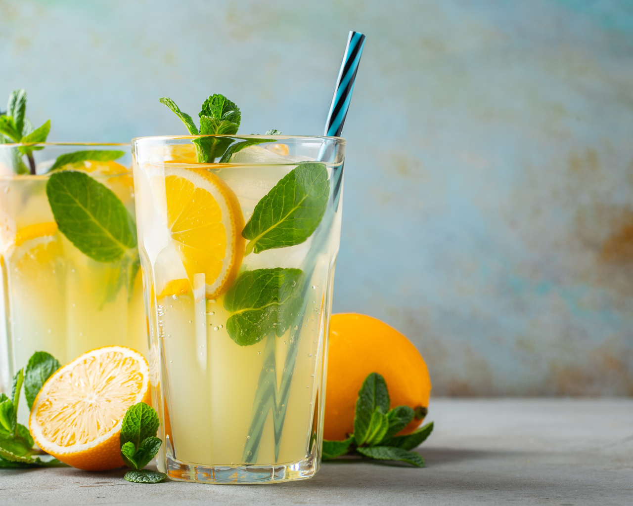 Два стакана лимонада на столе с лимоном