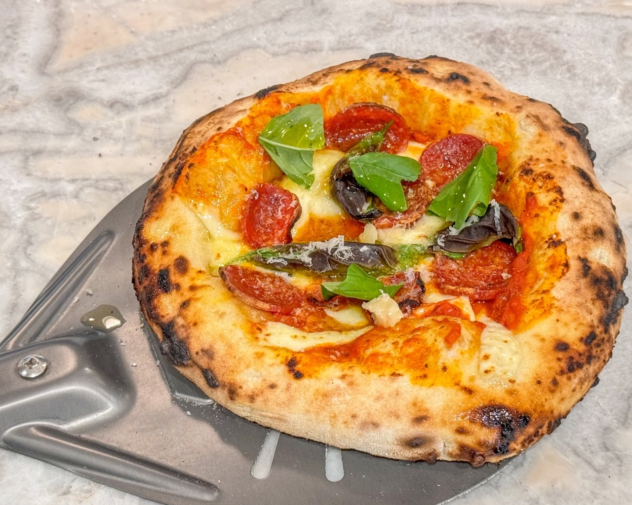 Маленькая пицца на лопате на столе