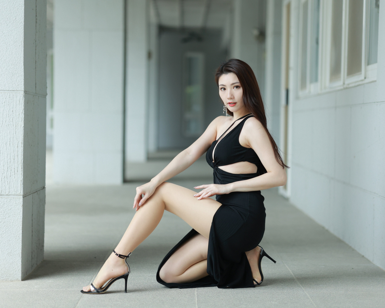 Девушка азиатка в черном наряде позирует для фото
