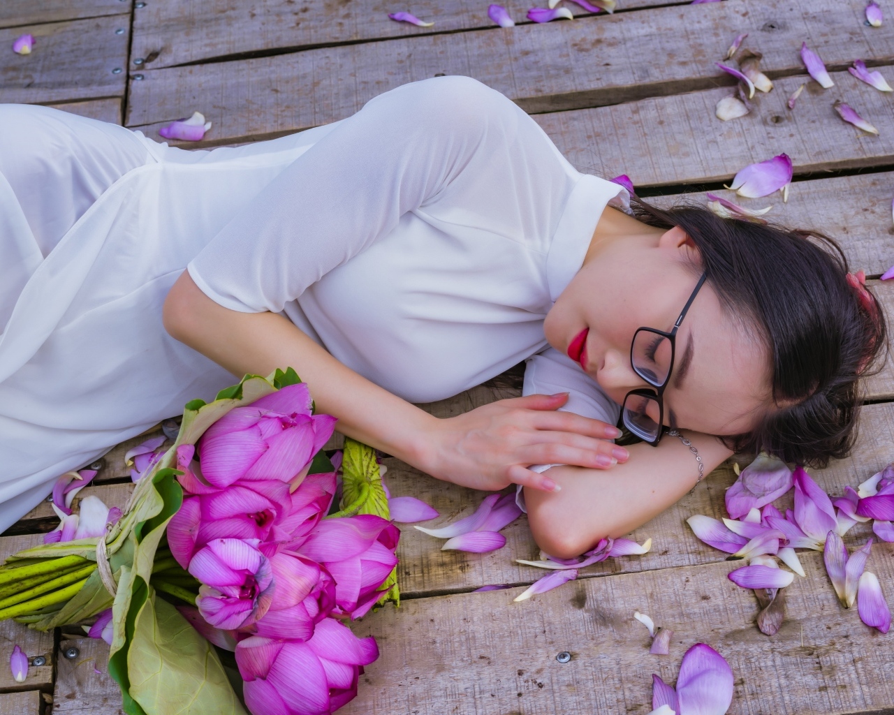 Девушка азиатка лежит с цветами лотоса