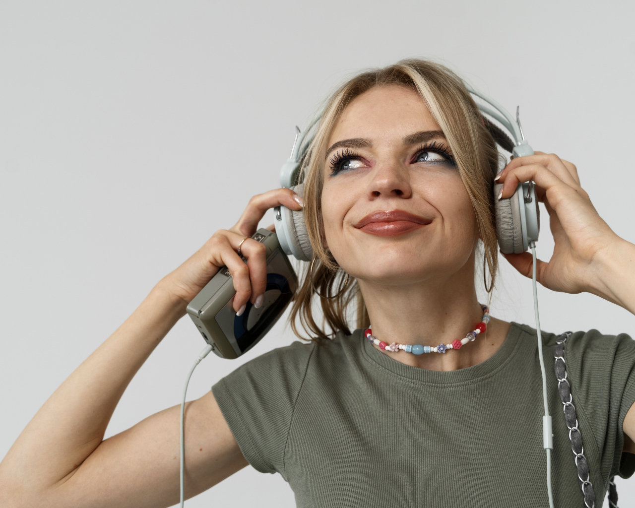 Красивая девушка в наушниках с плеером