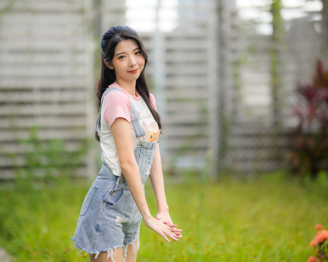 Милая девушка азиатка в джинсовом комбинезоне