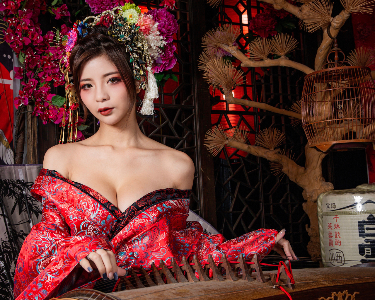 Милая девушка азиатка в красном кимоно с инструментом в руках