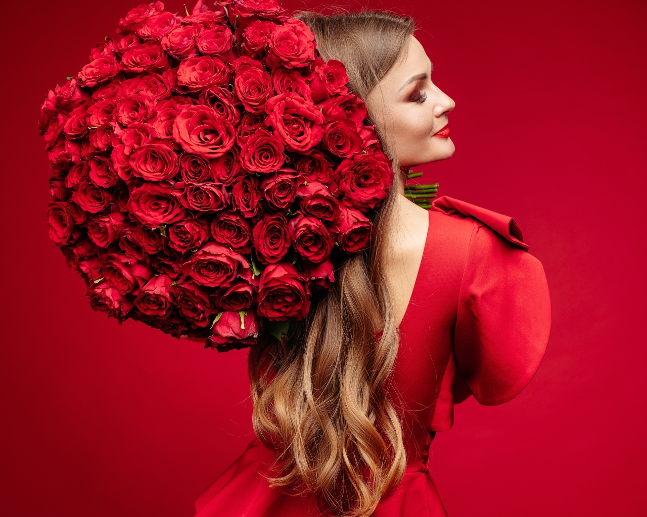 Девушка в красном платье с большим букетом роз