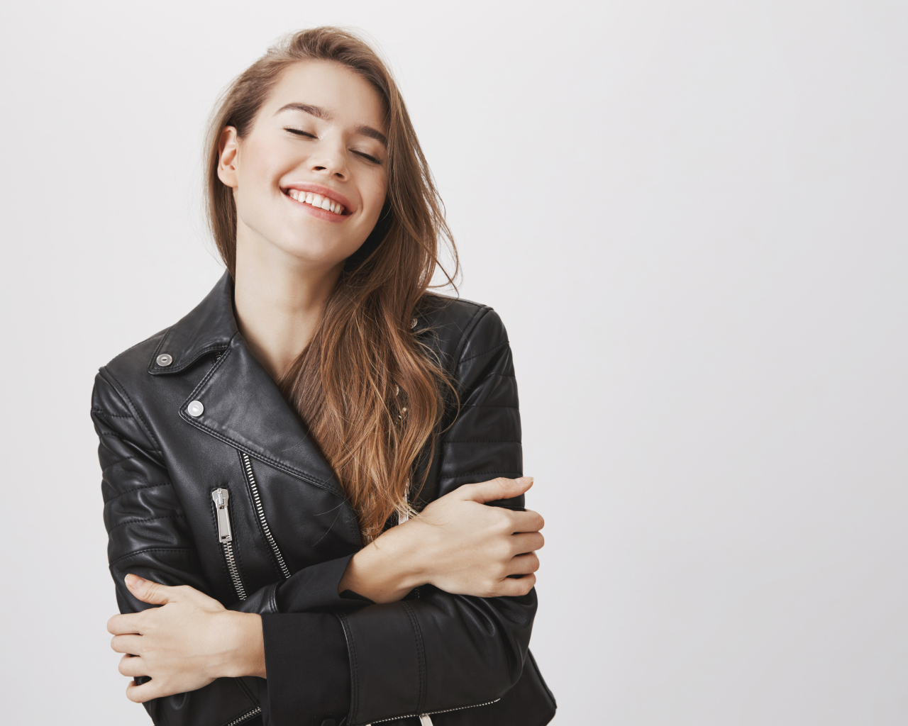 Девушка в черной кожаной куртке с закрытыми глазами