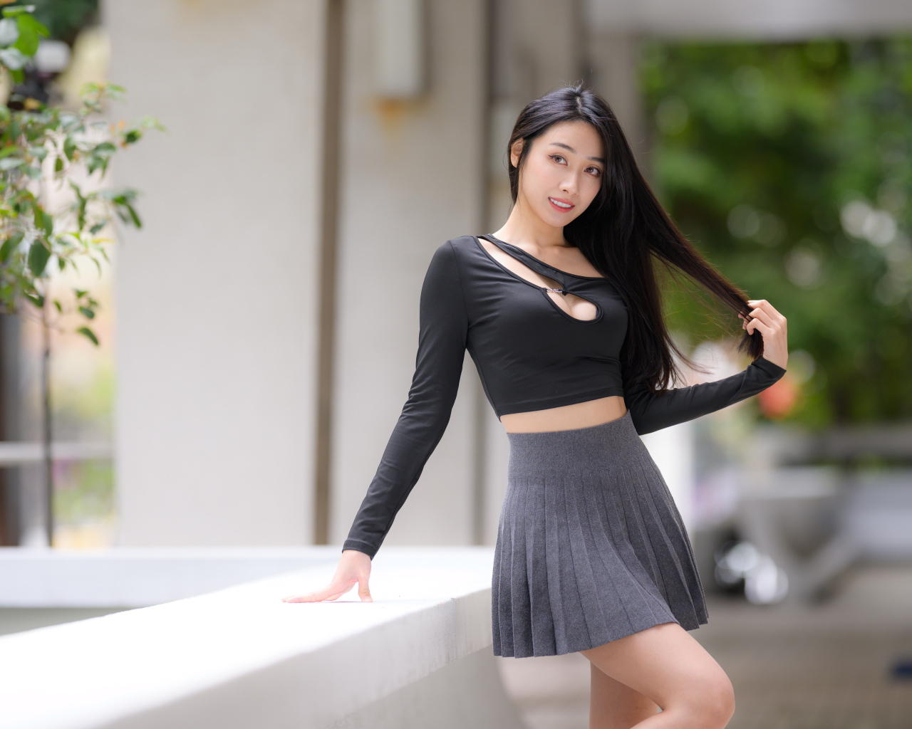 Молодая азиатка в короткой серой юбке