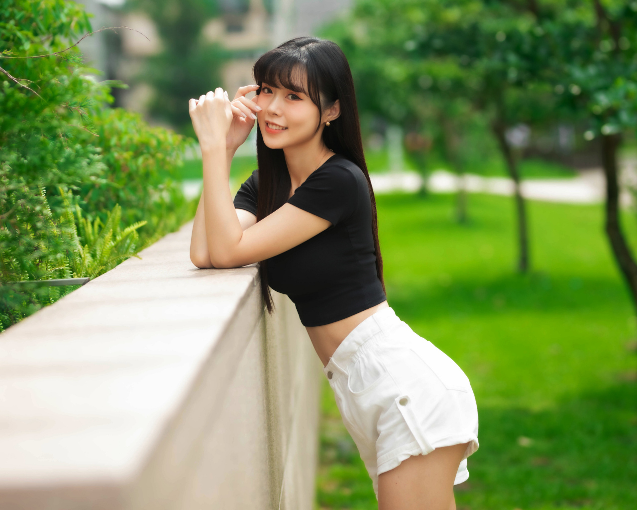 Молодая азиатка в белых шортах и футболке