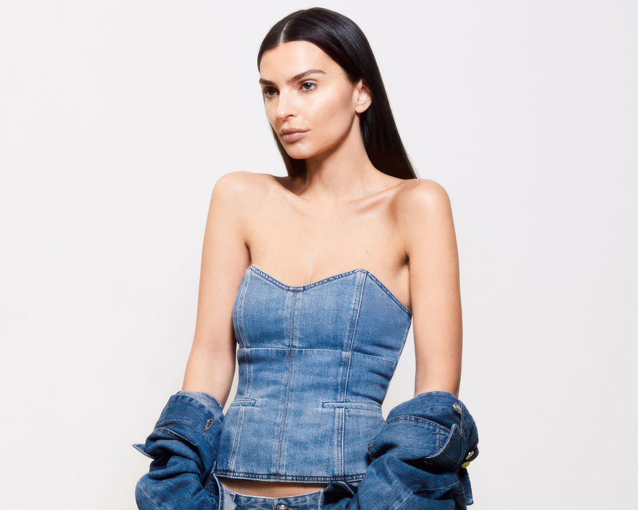 Модель Эмили Ратаковски в джинсовом костюме на белом фоне