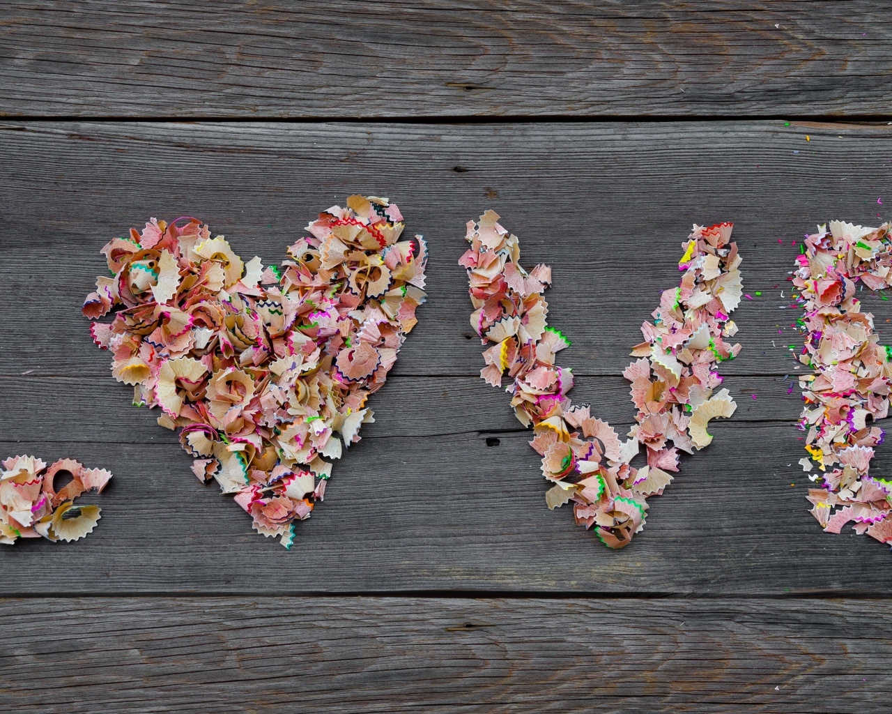 Надпись любовь из стружки карандашей на деревянном фоне