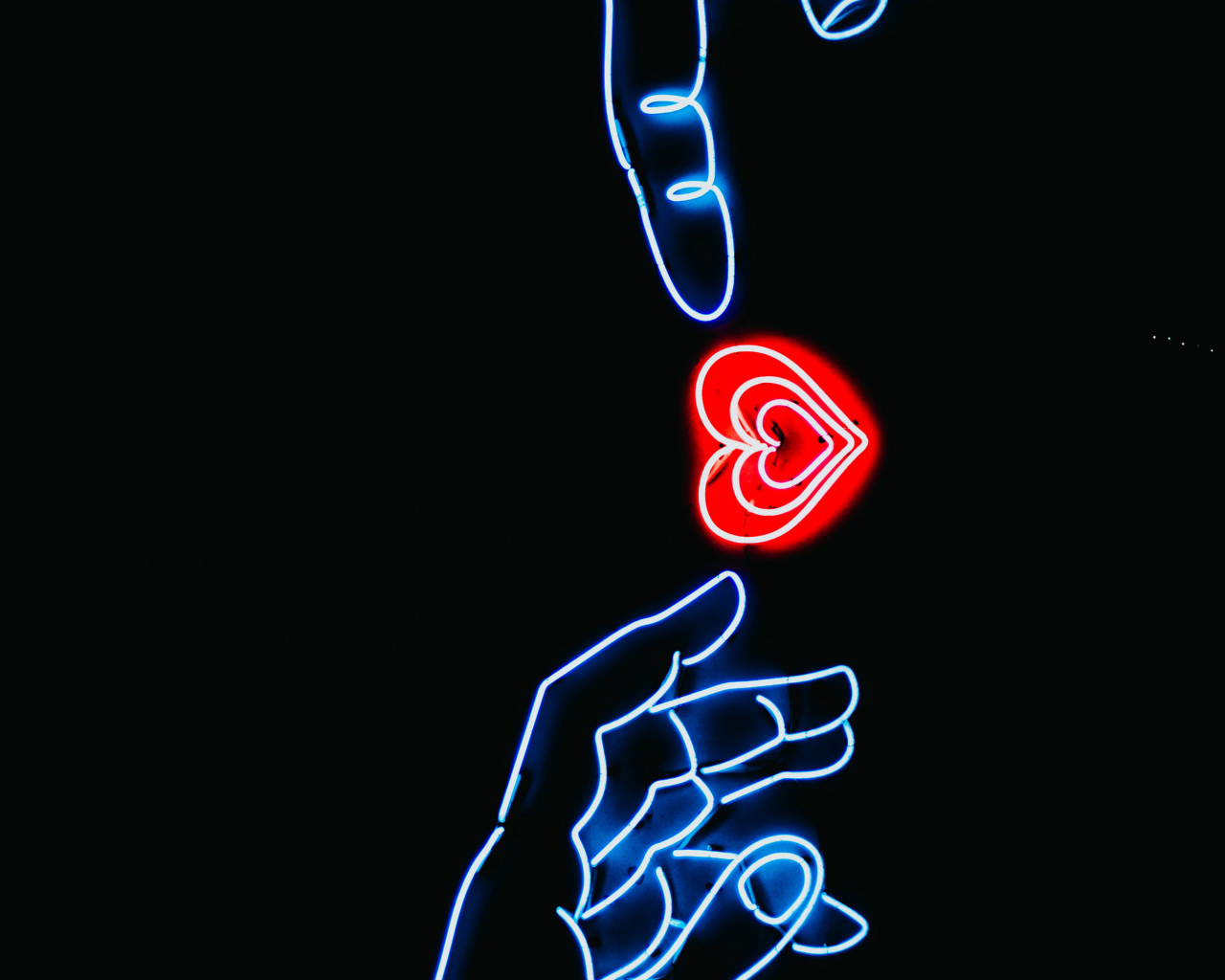 Неоновое красное сердце с руками на черном фоне