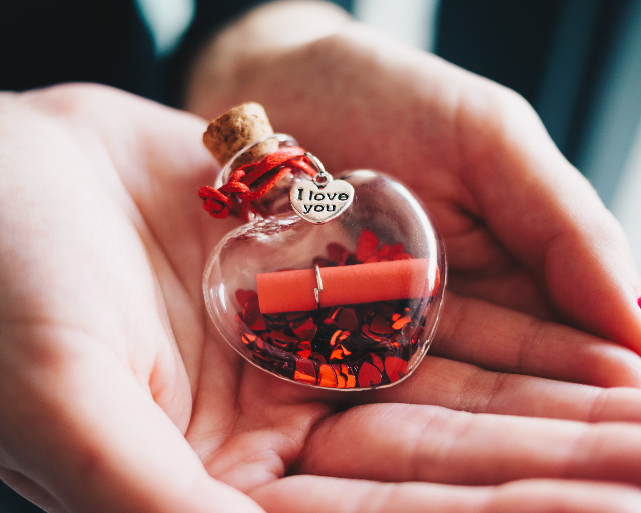Ладони с маленький стеклянным сердечком