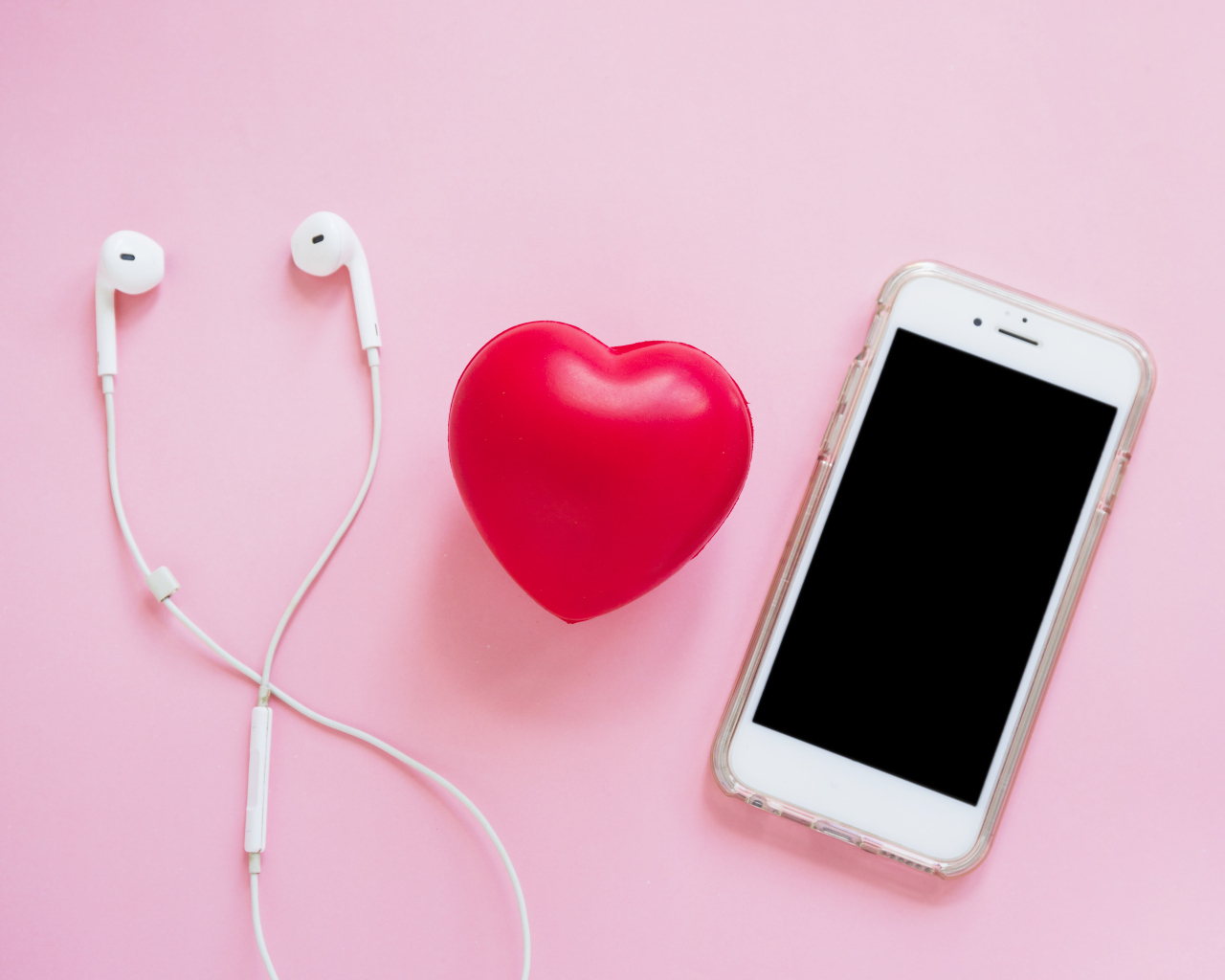 Телефон, наушники и красное сердце на розовом фоне
