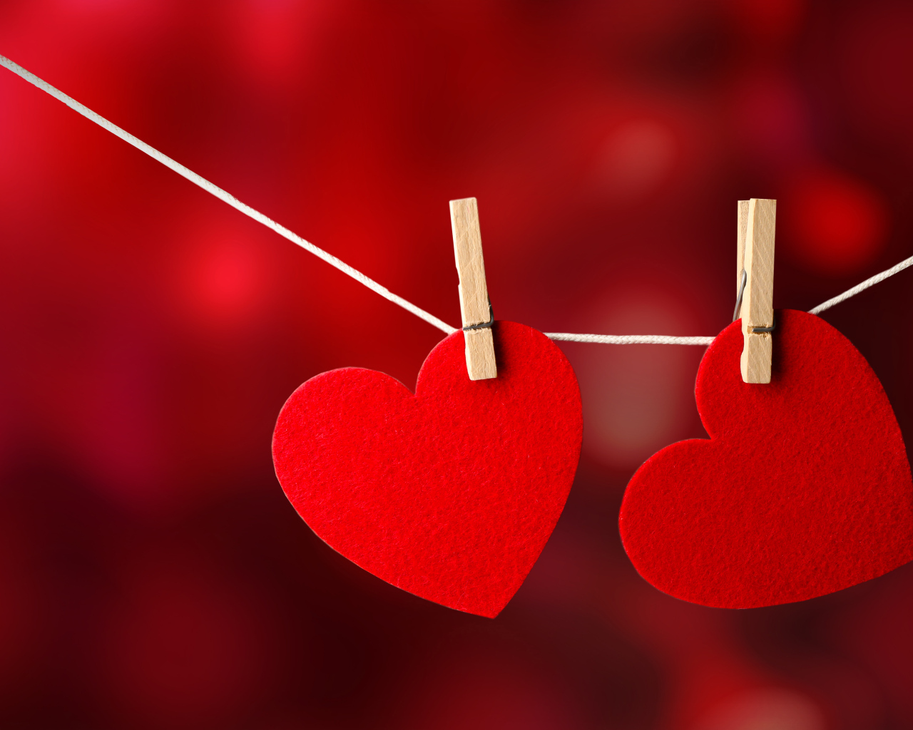 Два красных сердца висят на веревке