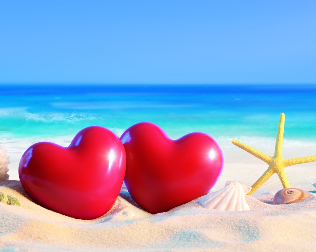 Два красных сердца на песке на пляже
