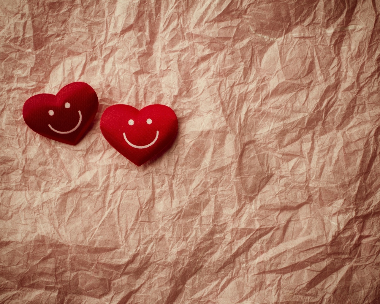 Два улыбающихся сердца на помятой бумаге
