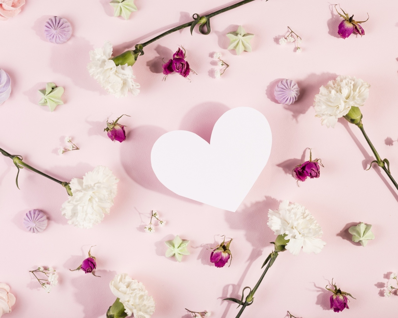 Белое бумажное сердце на розовом фоне с цветами