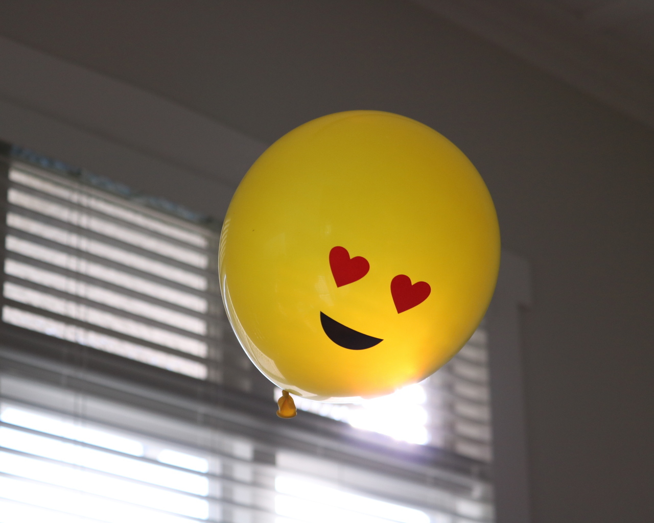 Желтый воздушный шарик с глазами в форме сердца