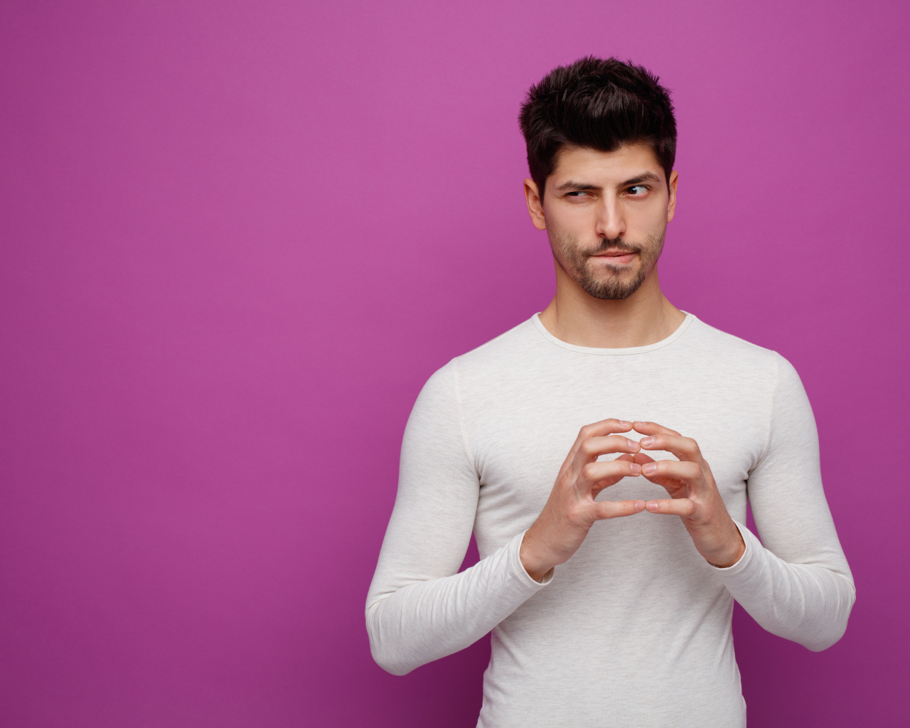 Хитрый мужчина в белом свитере на сиреневом фоне