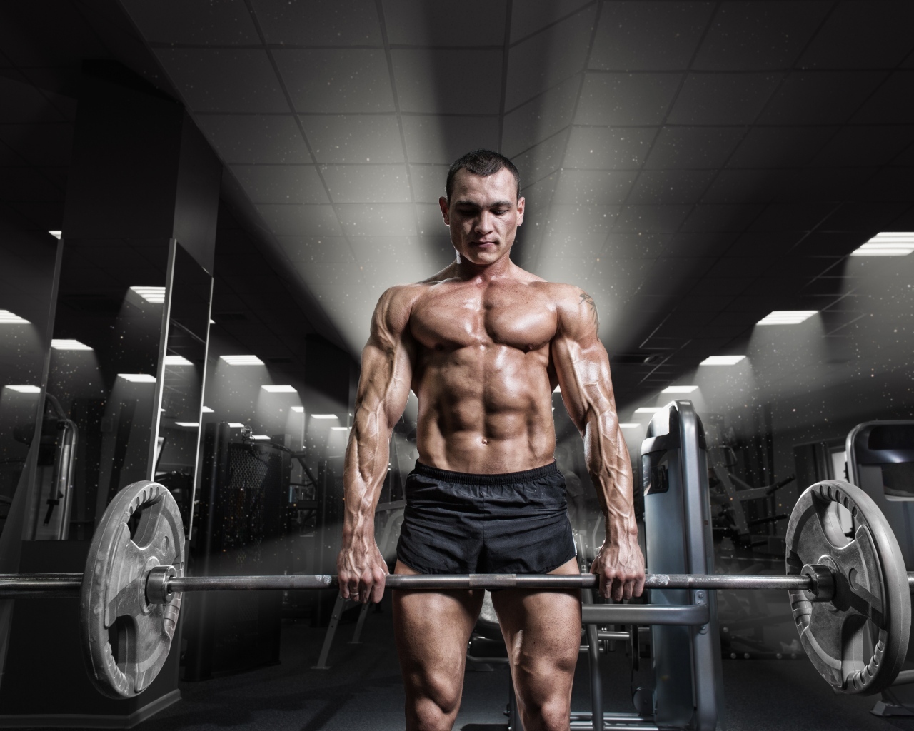 Сильный мужчина качает штангу в спортзале