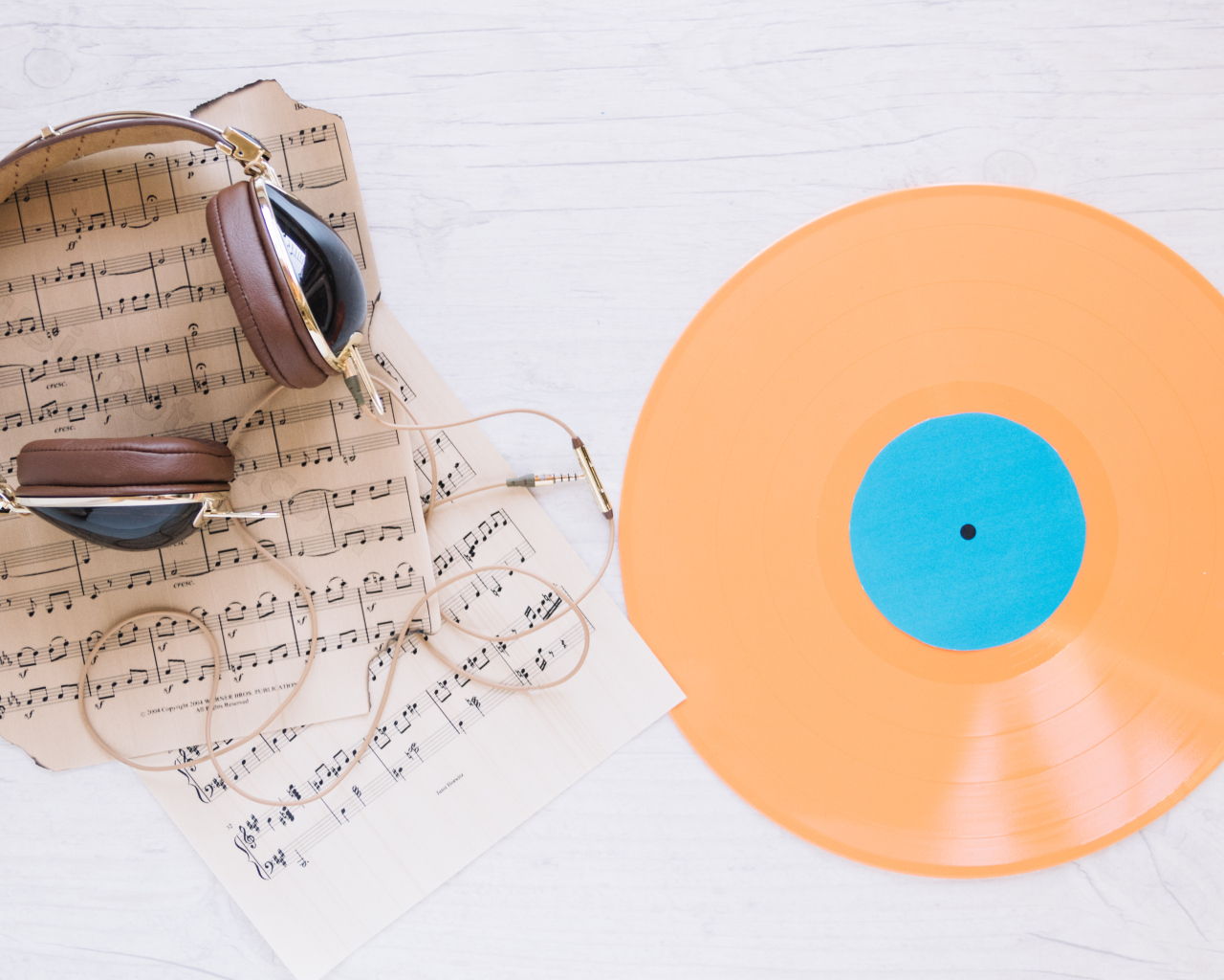 Наушники, ноты и виниловая пластинка на белом фоне