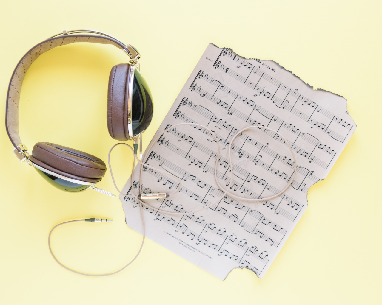 Старые ноты и наушники на желтом фоне