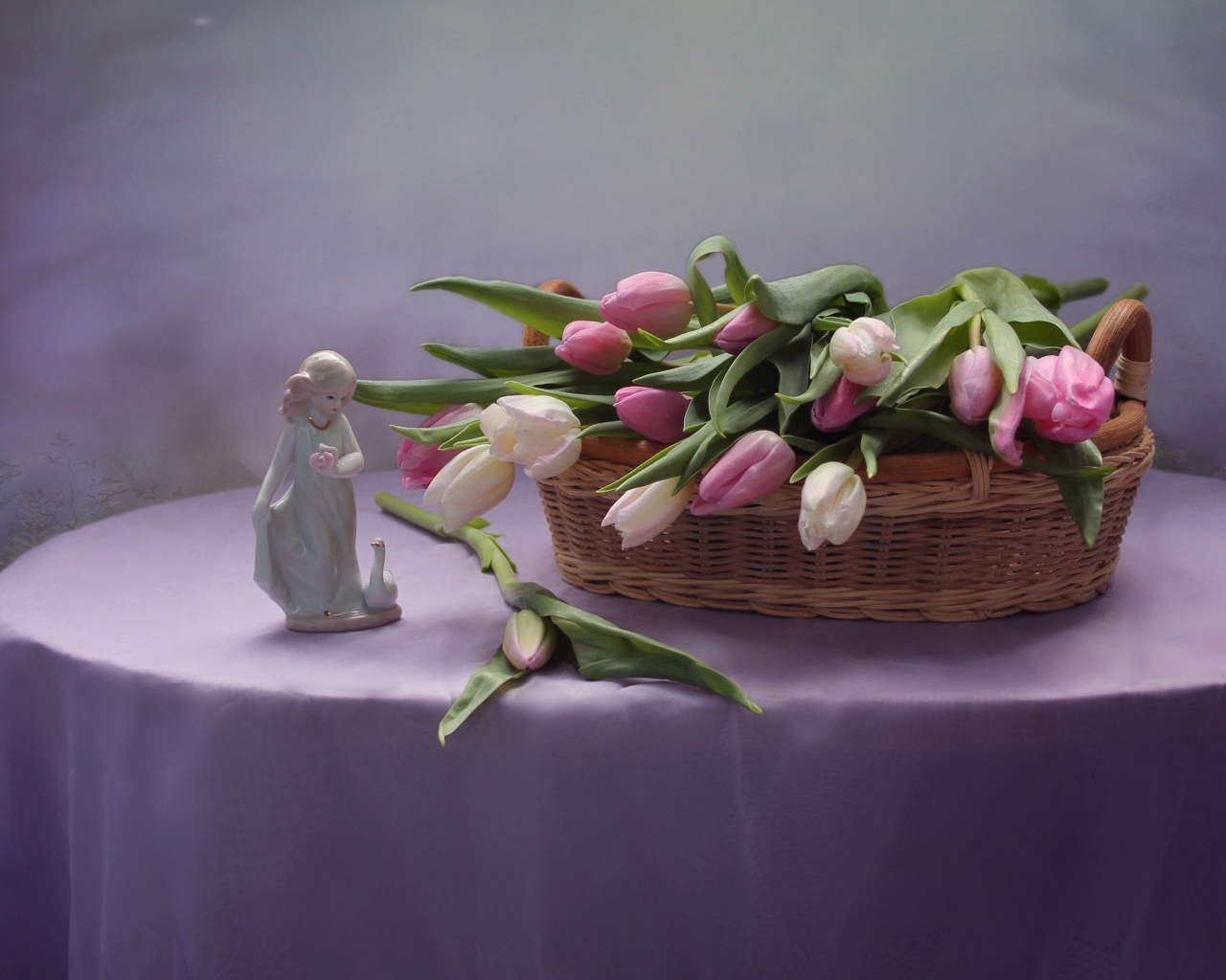 Корзина тюльпанов на столе со статуэткой