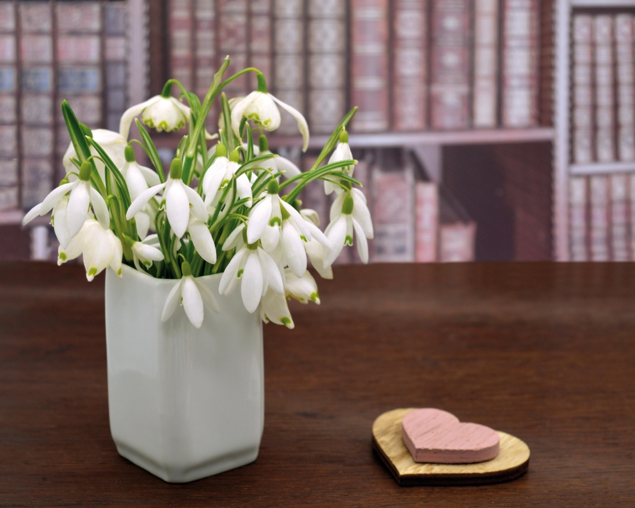 Букет белых подснежников в вазе на столе с сердечками