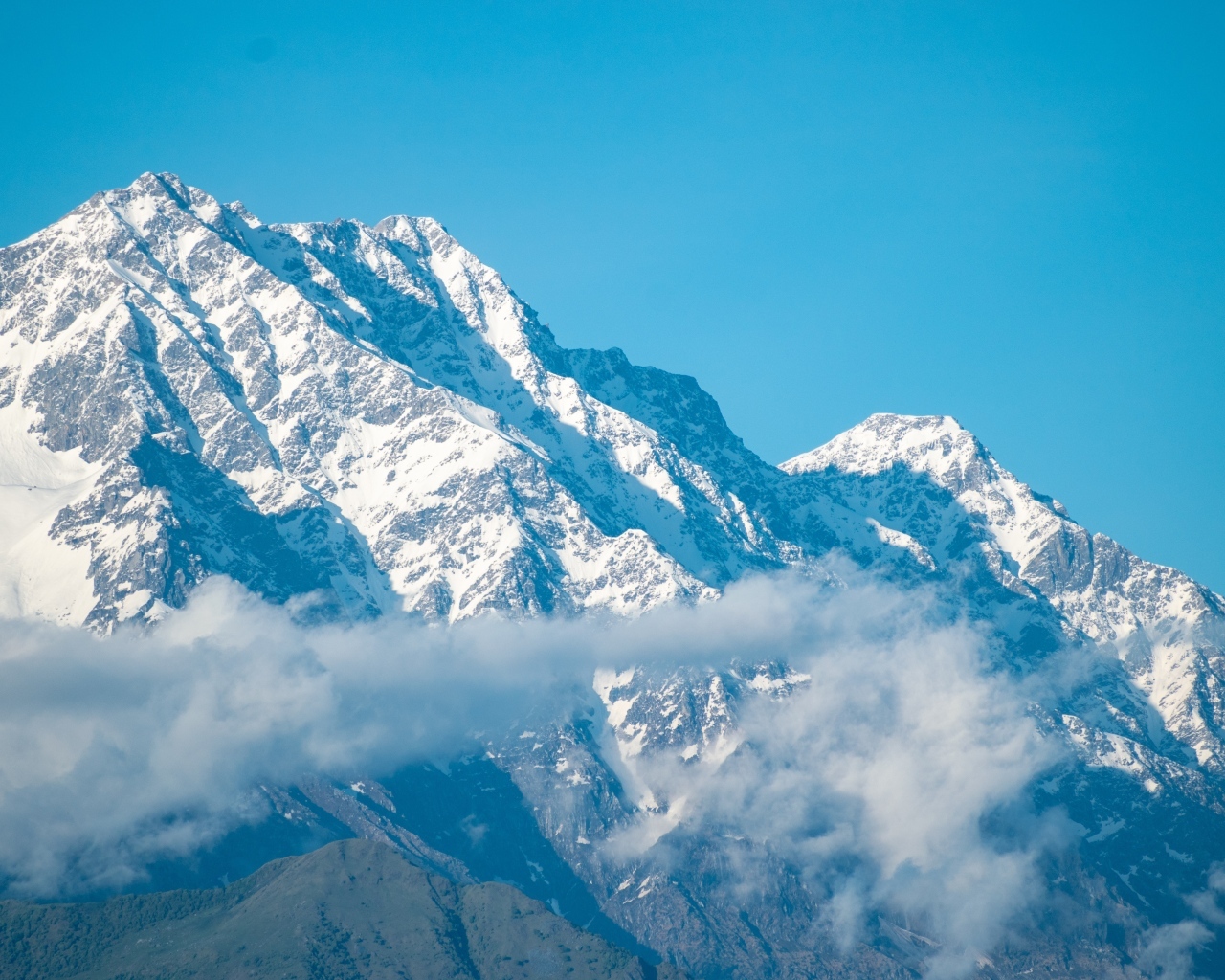 Высокие покрытые снегом горы на фоне голубого неба