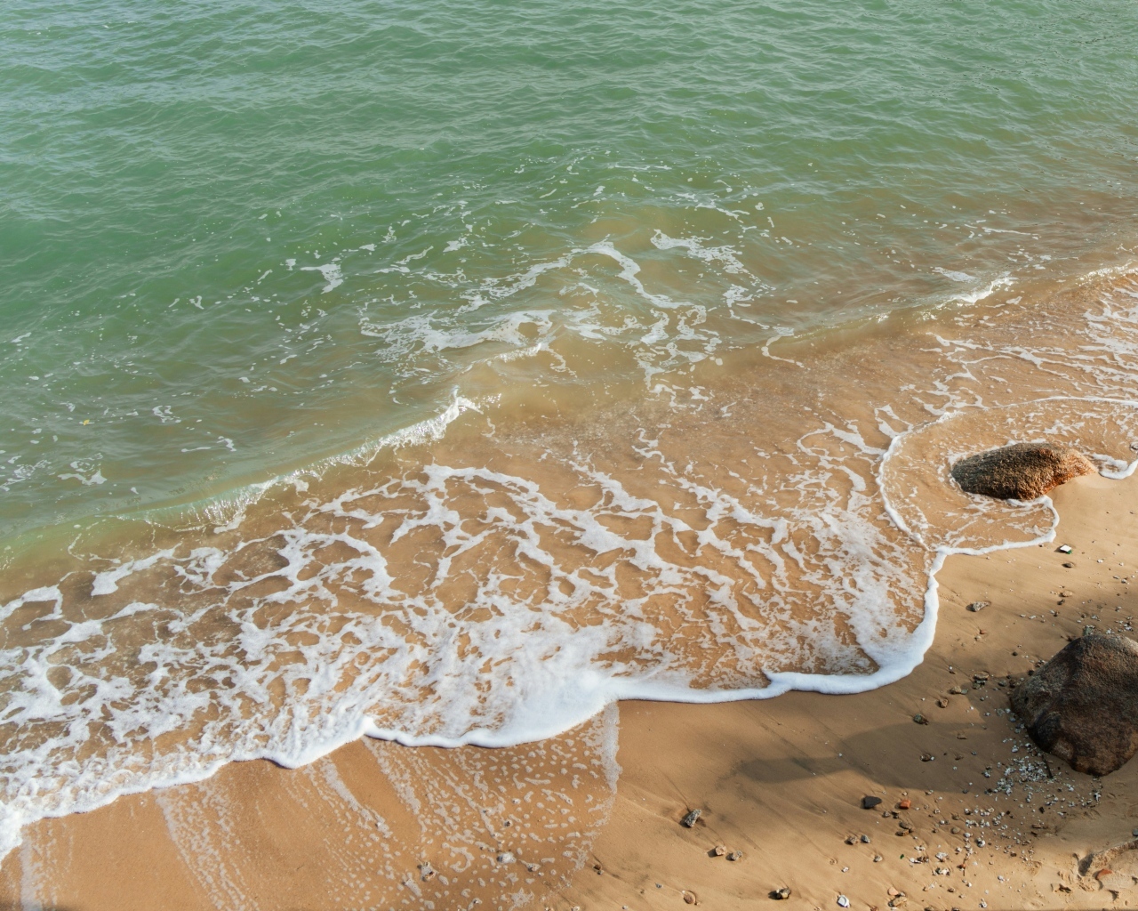 Красивая бирюзовая морская вода с белой пеной на песке