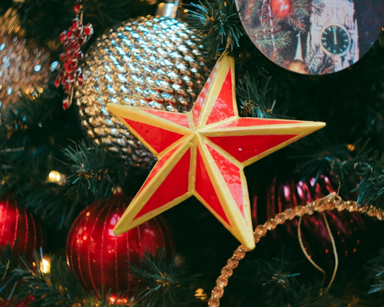 Большая красная звезда на елке с игрушками