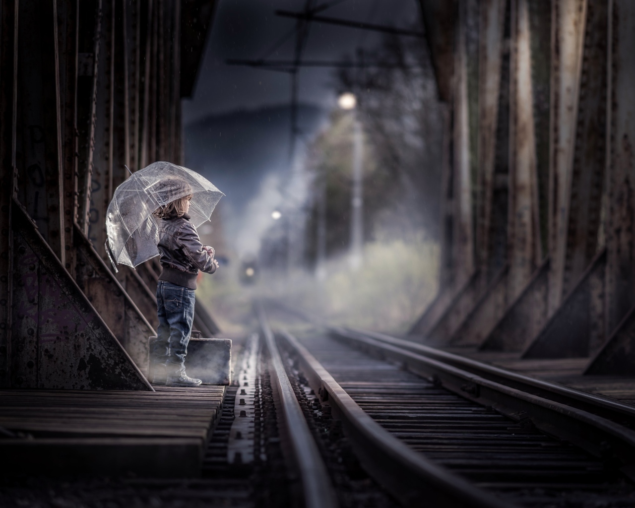 Ребенок под зонтом у железной дороги