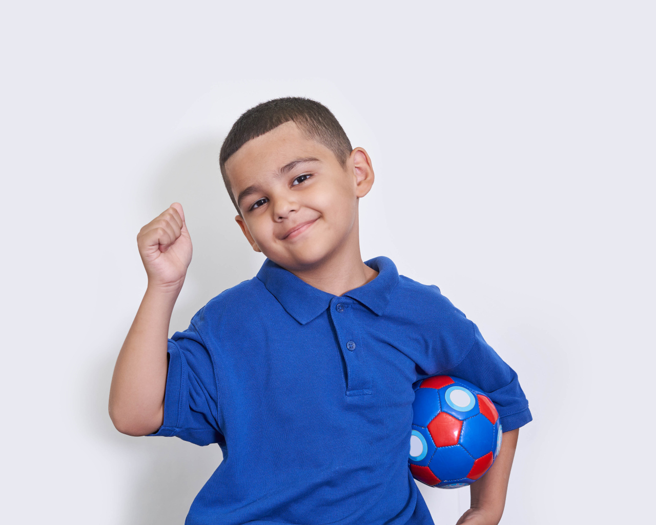 Милый мальчик с мячом на белом фоне