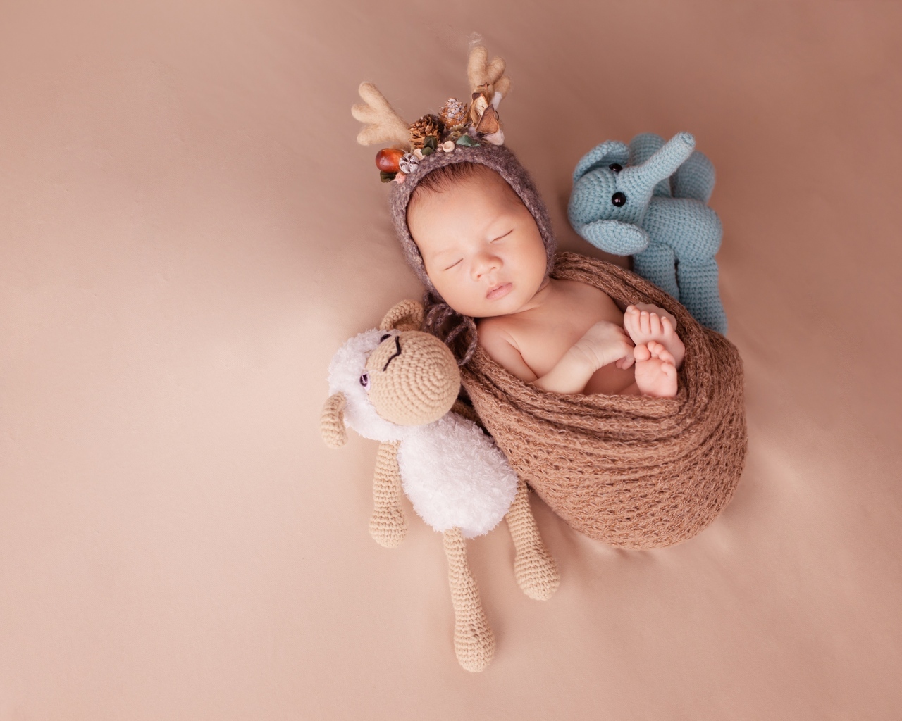 Маленький ребенок в костюме оленя с игрушкой