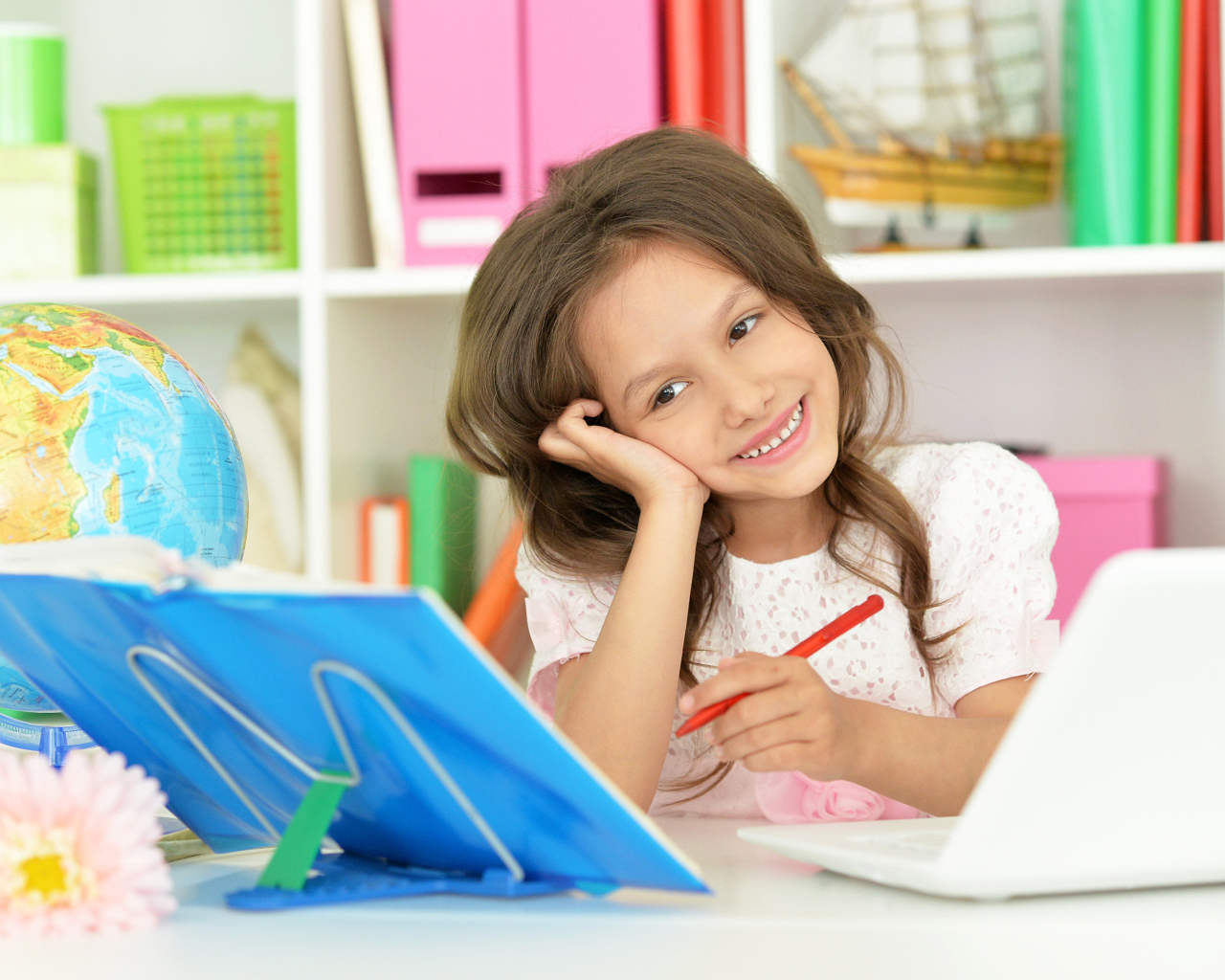 Улыбающаяся школьница делает уроки