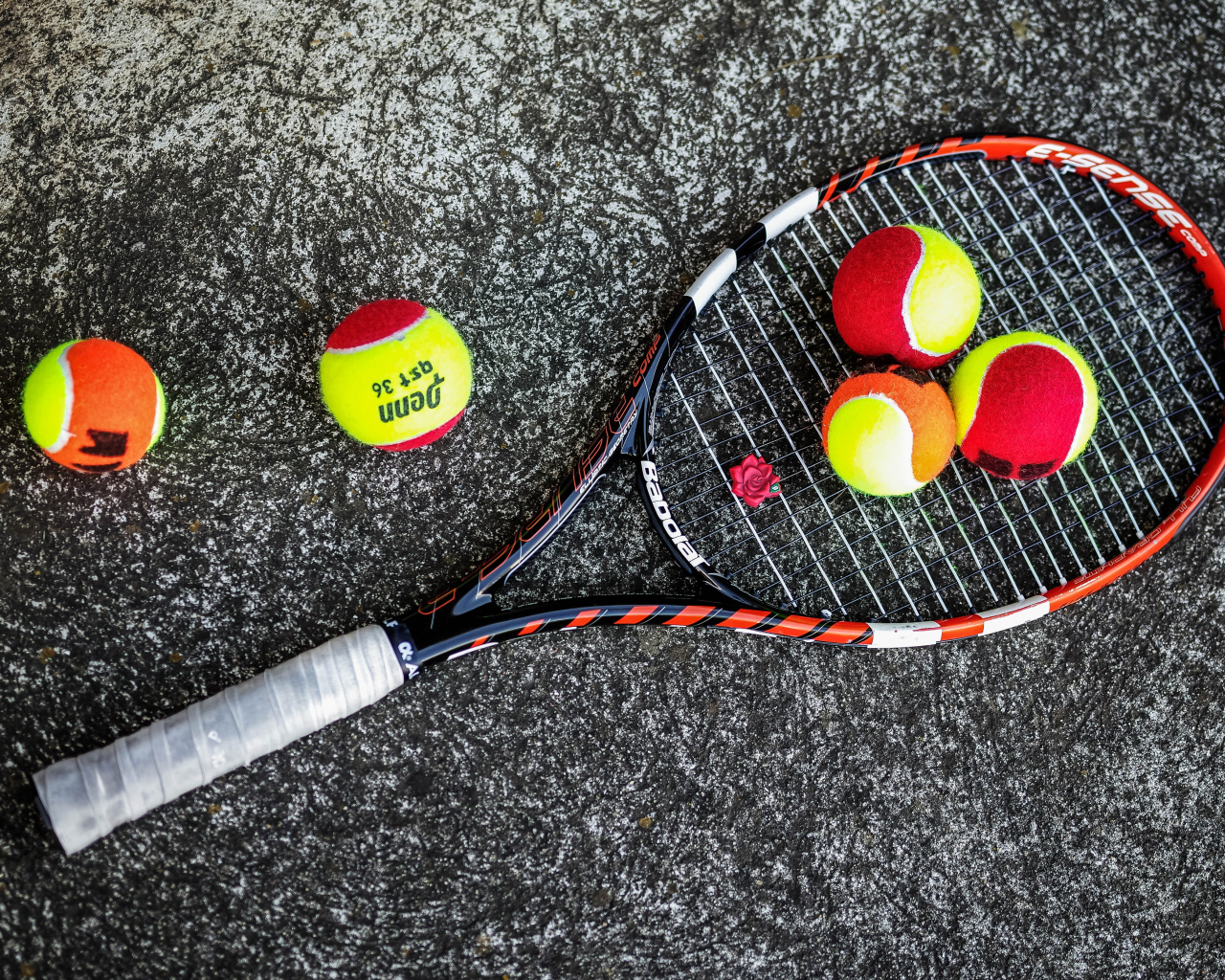 Ракетка и теннисные мячи на черном фоне