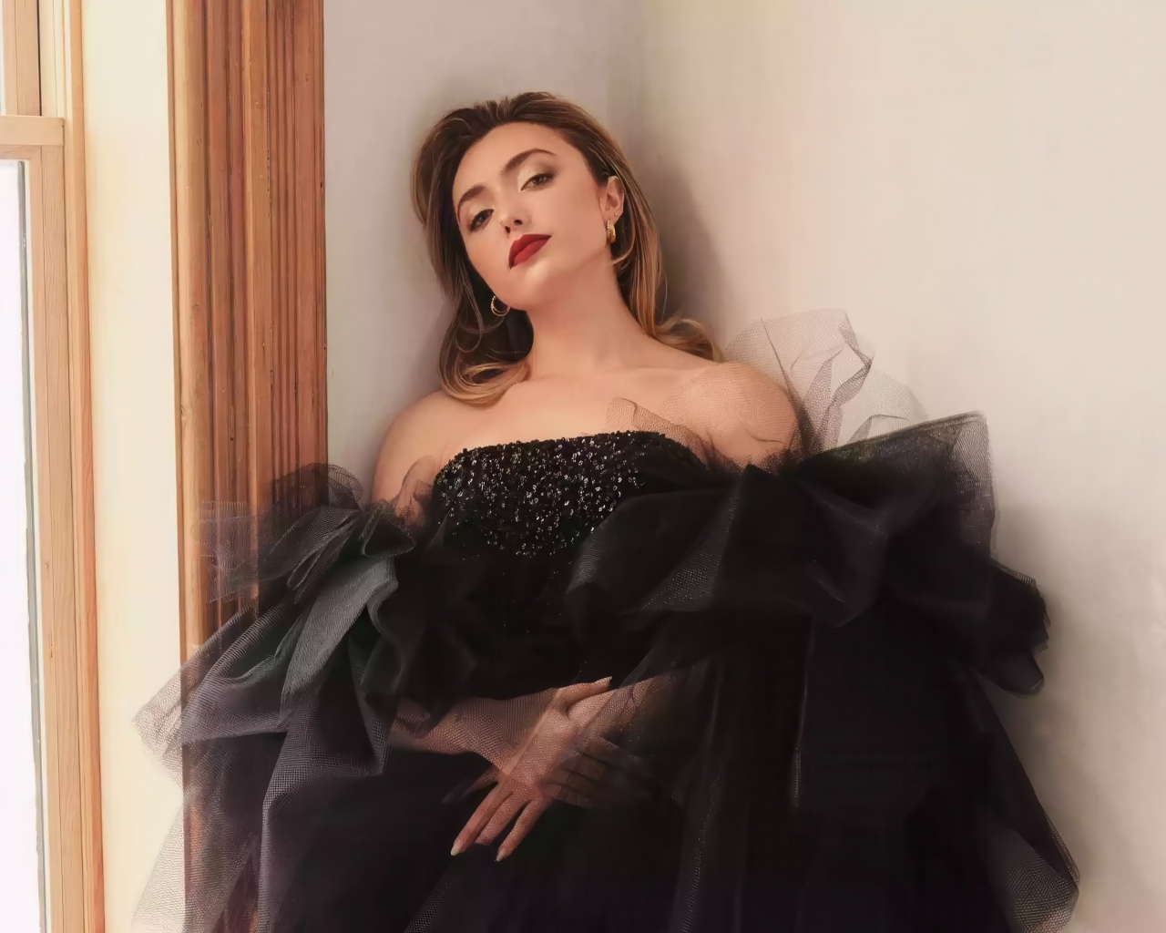 Актриса Пейтон Рой Лист в черном платье стоит у стены