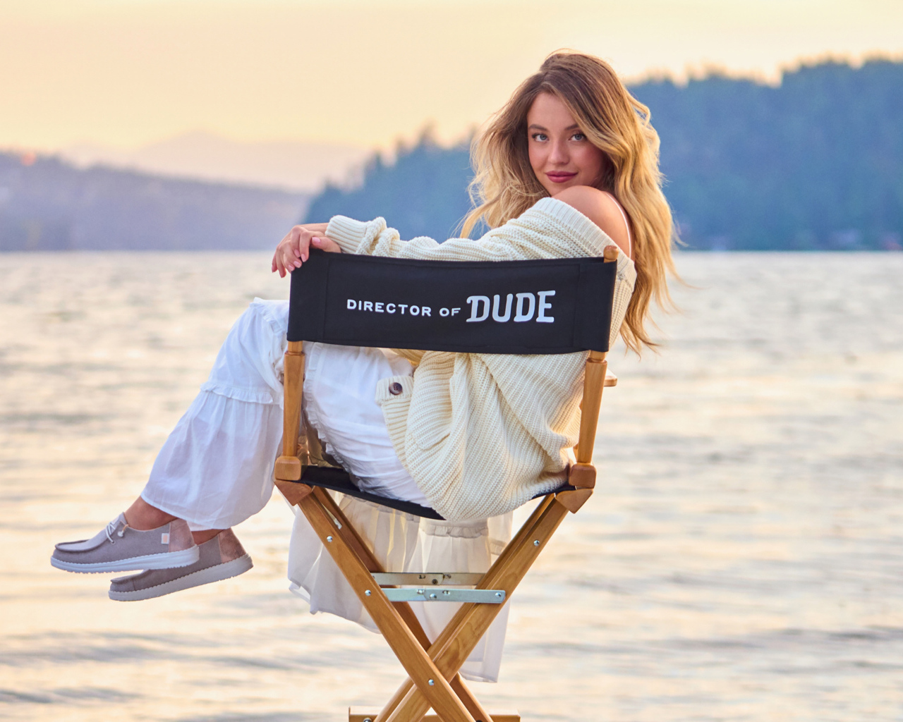 Актриса Сидни Суини сидит на стуле у озера