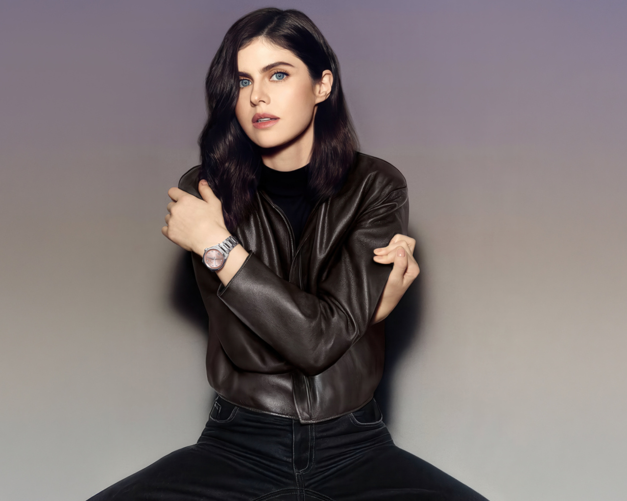 Американская актриса Александра Даддарио в черной куртке на фоне серой стены