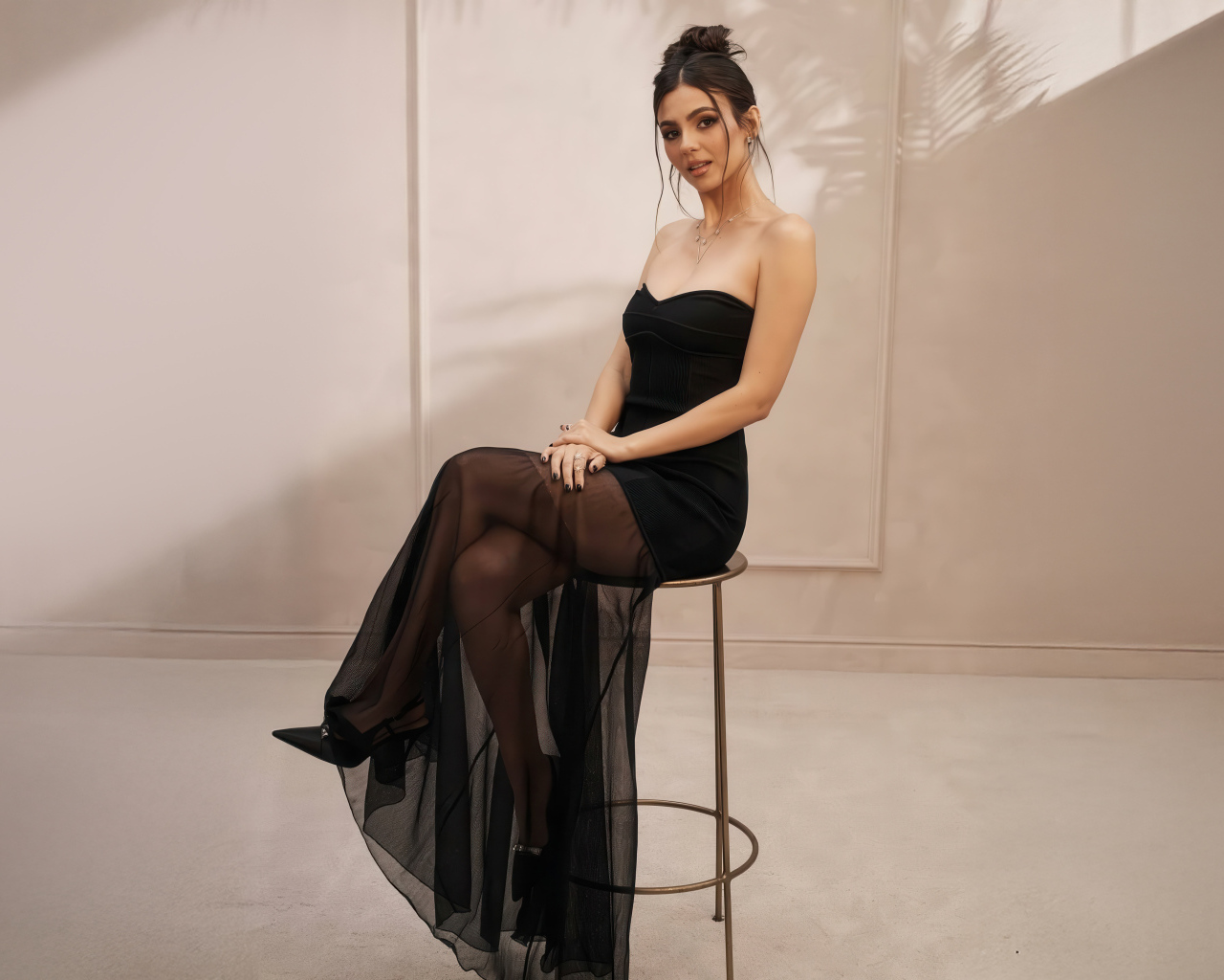 Американская актриса Виктория Джастис в черном платье на стуле