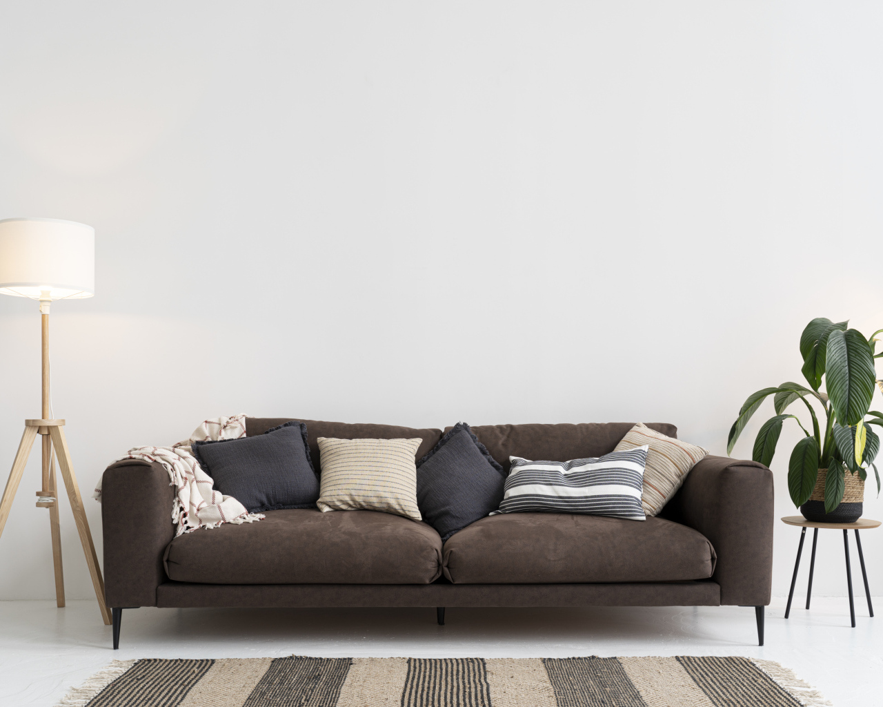 Коричневый диван у серой стены с лампой