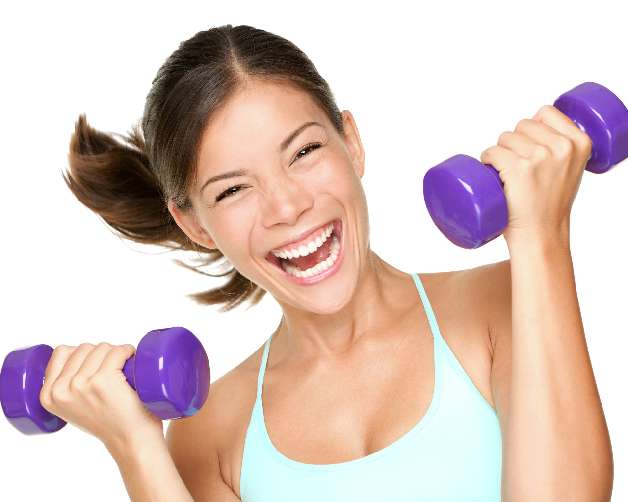 Веселая спортивная девушка с гантелями в руках