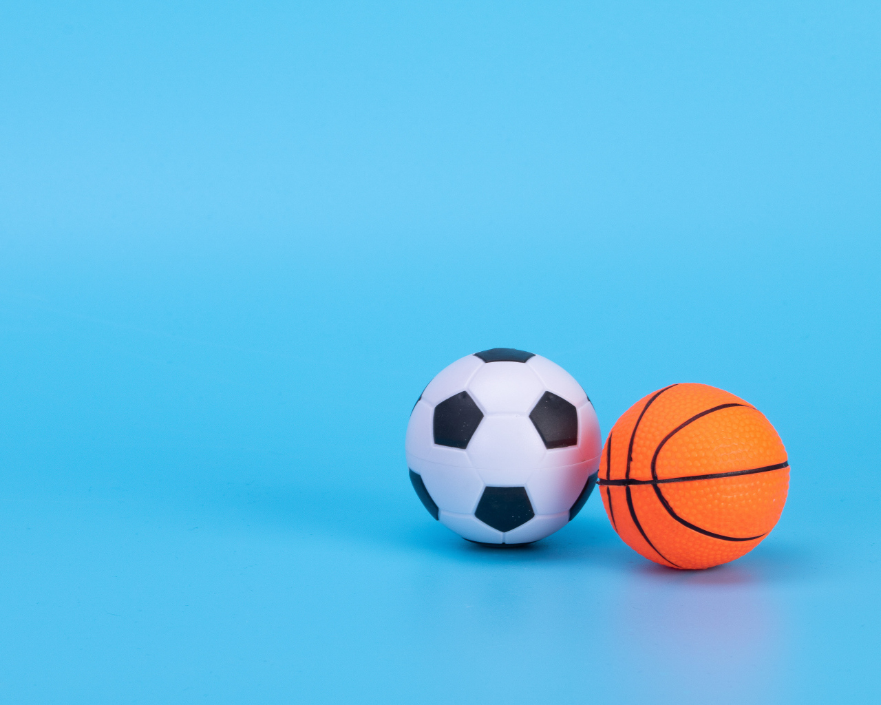 Футбольный и баскетбольный мяч на голубом фоне