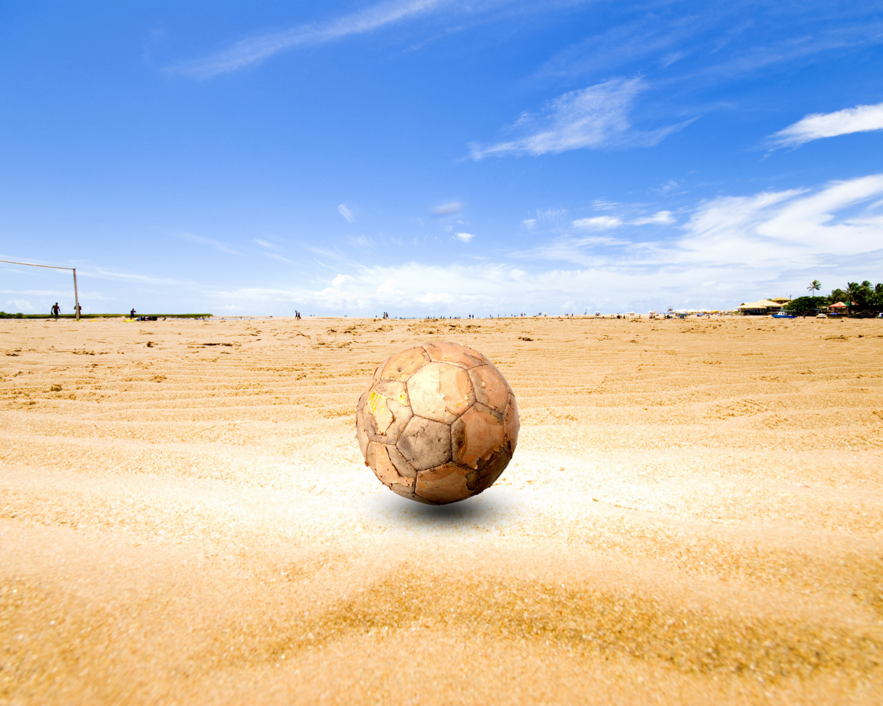 Старый футбольный мяч на песке